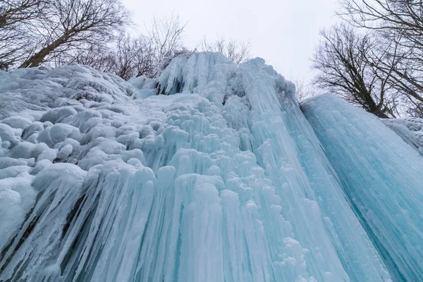 Wilder Fluss, wunderschöne gefrorene Wasserfälle und frischer Schnee in einem Bergwald, an einem kalten Wintertag — Stockfoto