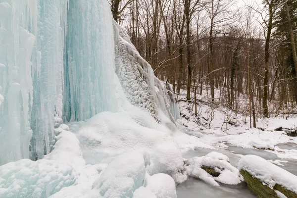 Wilder Fluss, wunderschöne gefrorene Wasserfälle und frischer Schnee in einem Bergwald, an einem kalten Wintertag — Stockfoto