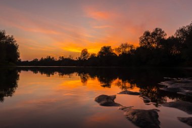 Muhteşem sonbaharda günbatımı bulutlu gökyüzü yansıması ile vahşi Nehri Panoraması