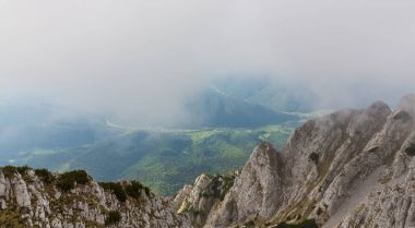 Sis bulutları ile yaz aylarında Transilvanya Alpleri'nde dağ manzarası