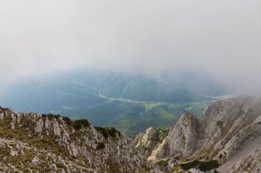 Sis bulutları ile yaz aylarında Transilvanya Alpleri'nde dağ manzarası