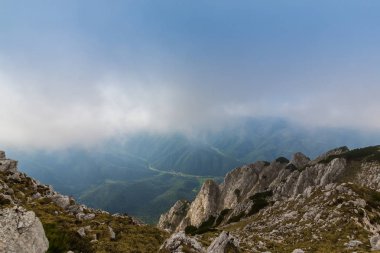 Sis bulutları ile yaz aylarında Transilvanya Alpleri'nde dağ manzarası