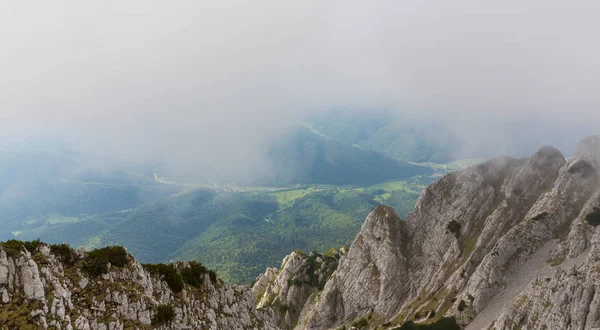 Sis bulutları ile yaz aylarında Transilvanya Alpleri'nde dağ manzarası