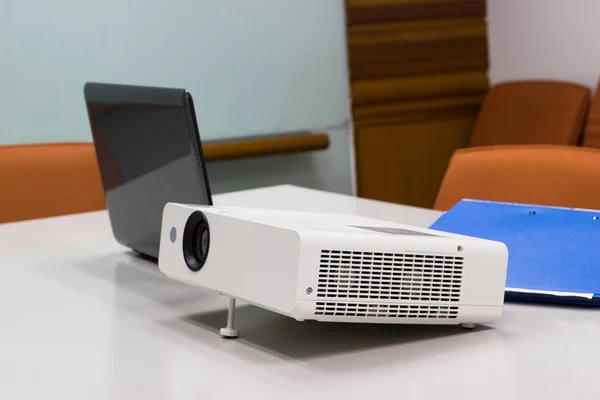 projector connected to Laptop with file folder on the table in a meeting room, Business Concept.