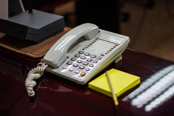 Λευκό Τηλέφωνο Μια Επιφάνεια Και Χαρτί Σημείωση Στην Αίθουσα Συνεδρίασης — Φωτογραφία Αρχείου