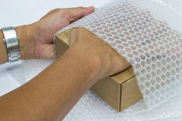 Man Använder Bubble Wrap Inslagna Packning Och Brun Låda Inverkan — Stockfoto