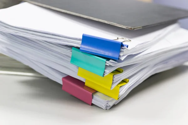 Stack of papers documents in archives files with paper clips on desk at offices, business concept.