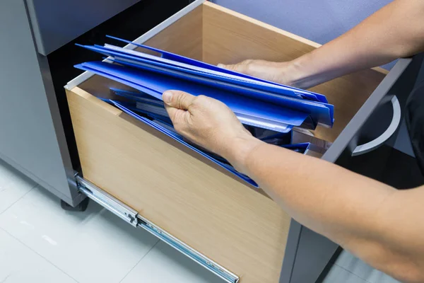 Hand of Man Search files document in a file cabinet in work office, concept office life.