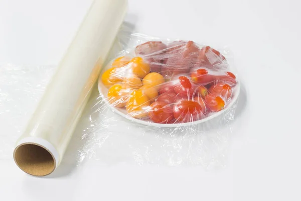 plastik ile sarılmış meyve beyaz arka plan üzerinde bir tablo koruma film.