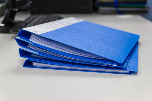 Blue file folder and Stack of business report paper file isolated with white background.