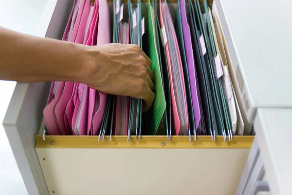 Hand of Man Search files document in a file cabinet in work office, concept office life.