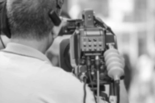blur - professional cameraman - covering the event with a video - black and white tone