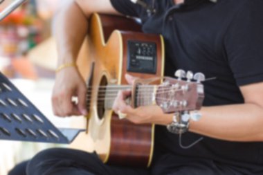 Bulanık görüntü - adam oyun akustik gitar Park'ta açık, Bangkok Tayland.
