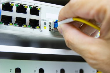 Technician connect fiber cable network to switch port in server  clipart