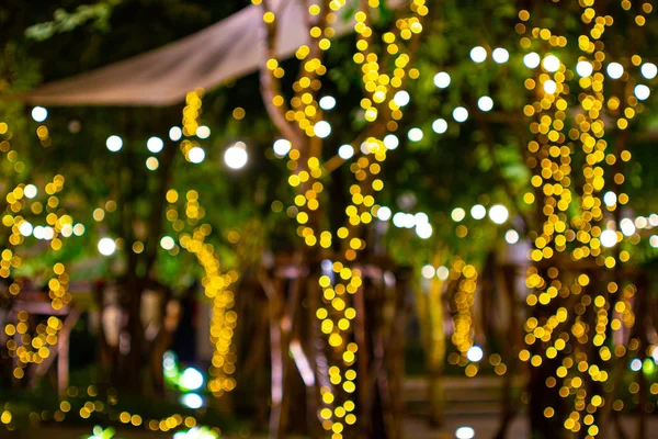 Borrão - bokeh Luzes decorativas de corda ao ar livre penduradas na árvore no jardim à noite - luzes decorativas de Natal — Fotografia de Stock