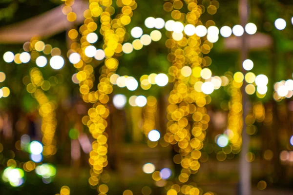 Blur - bokeh Decorative outdoor string lights hanging on tree in the garden at night time - decorative christmas lights