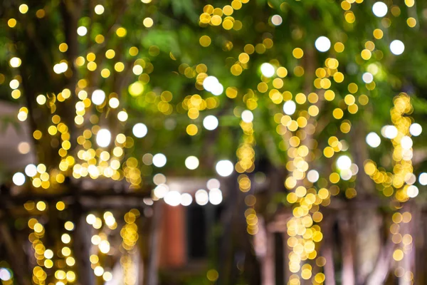 Desenfoque - Bokeh Luces decorativas de hilo al aire libre que cuelgan en el árbol en el jardín por la noche - luces decorativas de Navidad —  Fotos de Stock