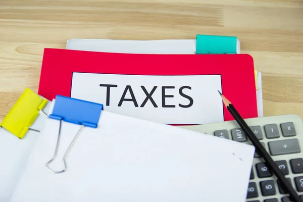 Documentos fiscales y archivos de papel, calculadora en el escritorio de madera en la oficina, concepto Pago anual de impuestos —  Fotos de Stock