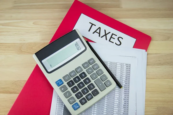 Documentos fiscales y archivos de papel, calculadora en el escritorio de madera en la oficina, concepto Pago anual de impuestos —  Fotos de Stock