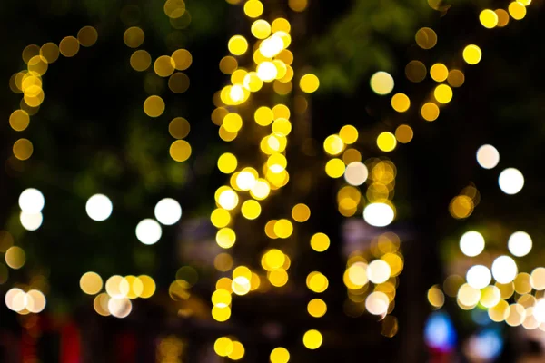Imagem borrada Luzes decorativas de corda ao ar livre penduradas na árvore — Fotografia de Stock