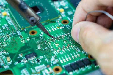 Teknisyenler elektronik tamir için bir lehimleme demir kullanıyor 
