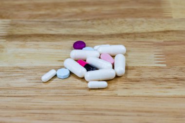 Tahta masadaki beyaz kapsüller. 