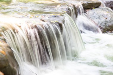 Şelaleden gelen su Asya 'daki kayalıklardan akıyor. 