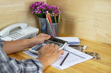 Çalışanlar gelir, gider ve iş hayatı konseptine sahip ofis hesap makineleri kullanırlar.