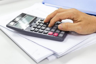 Çalışanlar gelir, gider ve iş hayatı konseptine sahip ofis hesap makineleri kullanırlar.