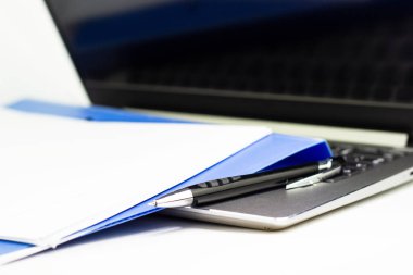 Mavi dosya klasörünü ve laptop bilgisayarını toplantı odasında, iş konseptinde kapat.