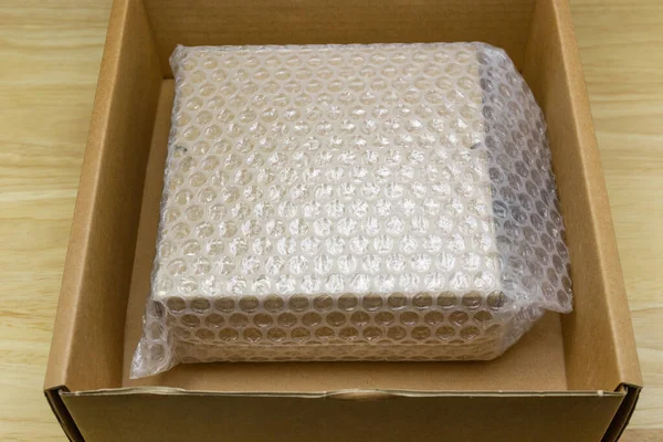 Blasen Bedecken Die Schachtel Mit Luftpolsterfolie Für Schutzprodukt Auf Holztisch — Stockfoto