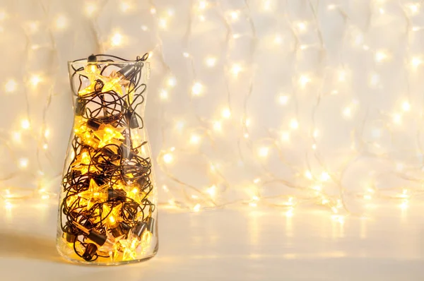 Guirlanda de Natal com lâmpadas em forma de estrela em um vaso transparente de vidro, decoração festiva de férias — Fotografia de Stock