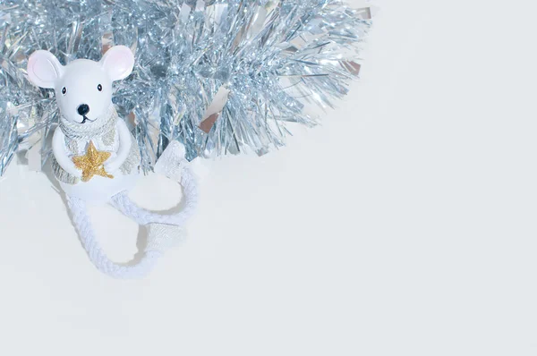 White festive toy of mouse or rat on the white background with silver shiny tinsel behind. — Stock Photo, Image