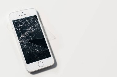 Beyaz arkaplanda ciddi şekilde kırılmış ekran görüntüsü olan modern akıllı telefon.