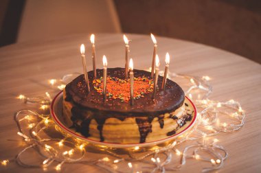 Home made cake with candles and decorated with red heart.