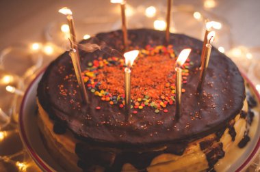 Home made cake with candles and decorated with red heart.