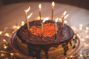 Home made cake with candles and decorated with red heart.