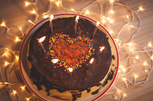 Hausgemachte Torte mit Kerzen und dekoriert mit rotem Herz. — Stockfoto