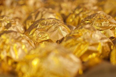 Altın folyoya sarılı bir kutu yuvarlak şeker. Makro atış. Lüks yemekler..