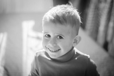 Gülümseyen 3 yaşında bir çocuk. Siyah beyaz fotoğraf..
