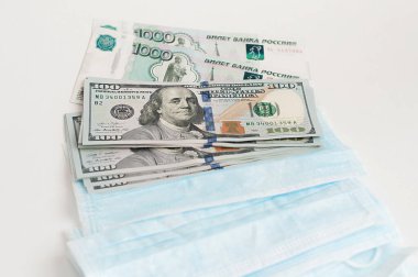 Amerikan doları ve Rus rublesiyle tıbbi yüz maskeleri. Salgın hastalıkların önlenmesi ve ekonomik kriz kavramı.