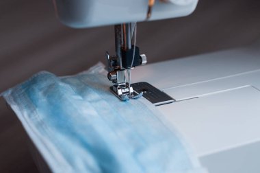Evdeki dikiş makinesine tıbbi maske dikiyorum..