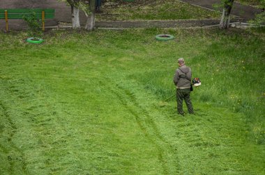 14 Mayıs 2020, Voronezh, Rusya. Bahçe çim biçme makinesiyle çim biçen bir adam. Rus konut hizmetleri.