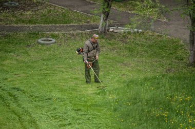 14 Mayıs 2020, Voronezh, Rusya. Bahçe çim biçme makinesiyle çim biçen bir adam. Rus konut hizmetleri.