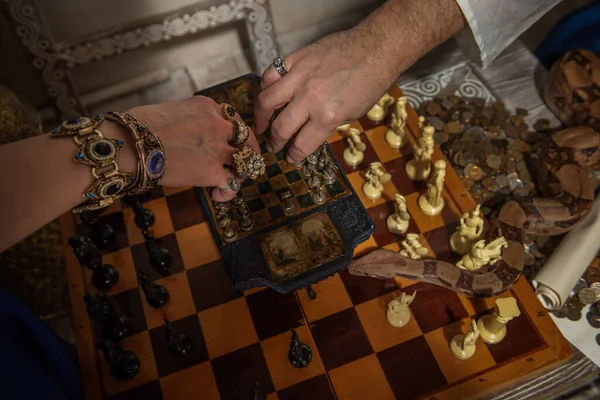 Schachspiel Hände Mit Dekorationen Und Einer Kriechenden Schlange — Stockfoto