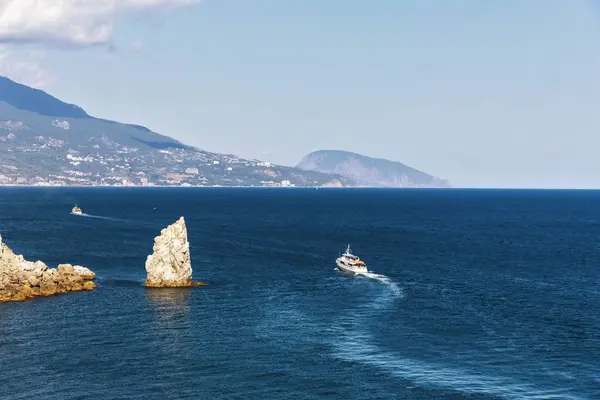 海と岩の背景にプレジャー ボート. — ストック写真