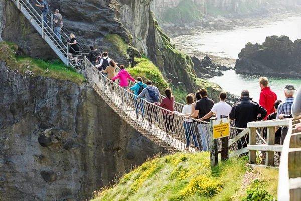 Touristen besuchen die Seilbrücke Carrick-a-rede in der Grafschaft Antrim im Norden Irlands — Stockfoto