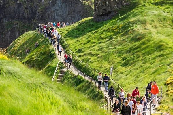 Οι τουρίστες που επισκέπτονται Carrick-a-Rede γέφυρα σχοινί στην κομητεία Antrim της Βόρειας Ιρλανδίας — Φωτογραφία Αρχείου