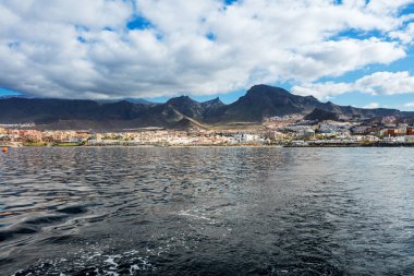 Canlı sahne ve derin mavi suları bir yat görüldüğü gibi Tenerife Batı kıyı şeridi. Uyuyan Teide yanardağı arka planda görülebilir. Birçok turizm tatil kıyı şeridi gözden kaçırmak..
