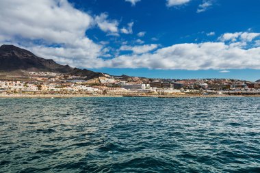 Canlı sahne ve derin mavi suları bir yat görüldüğü gibi Tenerife Batı kıyı şeridi. Uyuyan Teide yanardağı arka planda görülebilir. Birçok turizm tatil kıyı şeridi gözden kaçırmak..